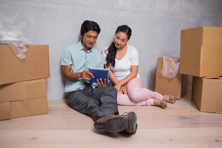 Asian couple reviewing information provided by the law firm Lawrence and Tkachuk for individuals getting ready to buy or sell a home or house and need legal services related to the completion of real estate transactions